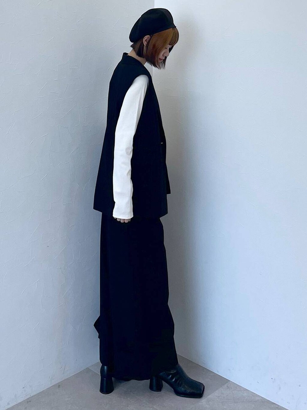 ブラック系のその他パンツ、ブラック系のベスト、ホワイト系のTシャツ/カットソーを着用したレディースの秋コーディネートの5枚目の写真