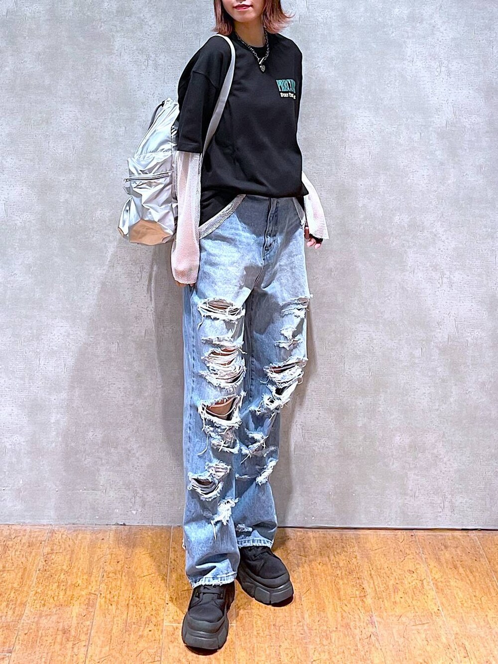 シルバー系のショルダーバッグ、ブラック系のTシャツ/カットソー、ブルー系のデニムパンツを着用したレディースの春コーディネートの2枚目の写真