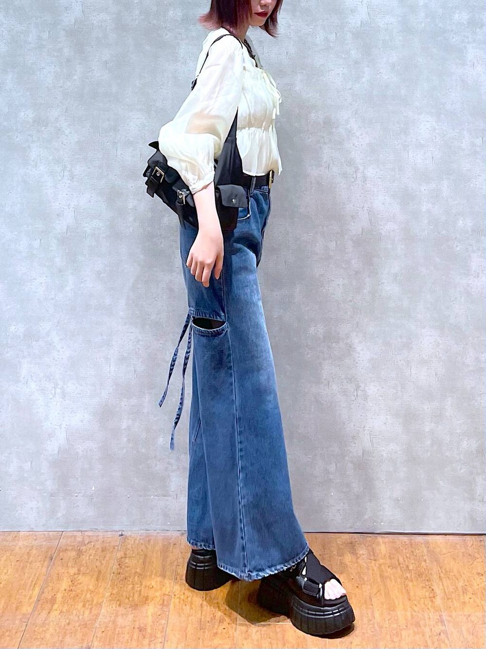 ブラック系のスニーカー、ブラック系のショルダーバッグ、ベージュ系のシャツ/ブラウスを着用したレディースの春コーディネートの3枚目の写真