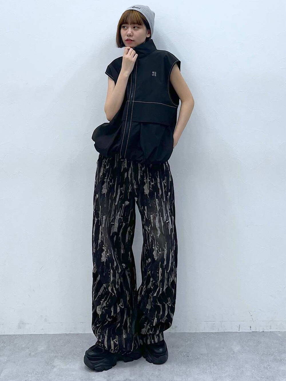 ブラック系のスニーカー、ブラック系のベスト、ブラック系のデニムパンツを着用したレディースの夏コーディネートの4枚目の写真