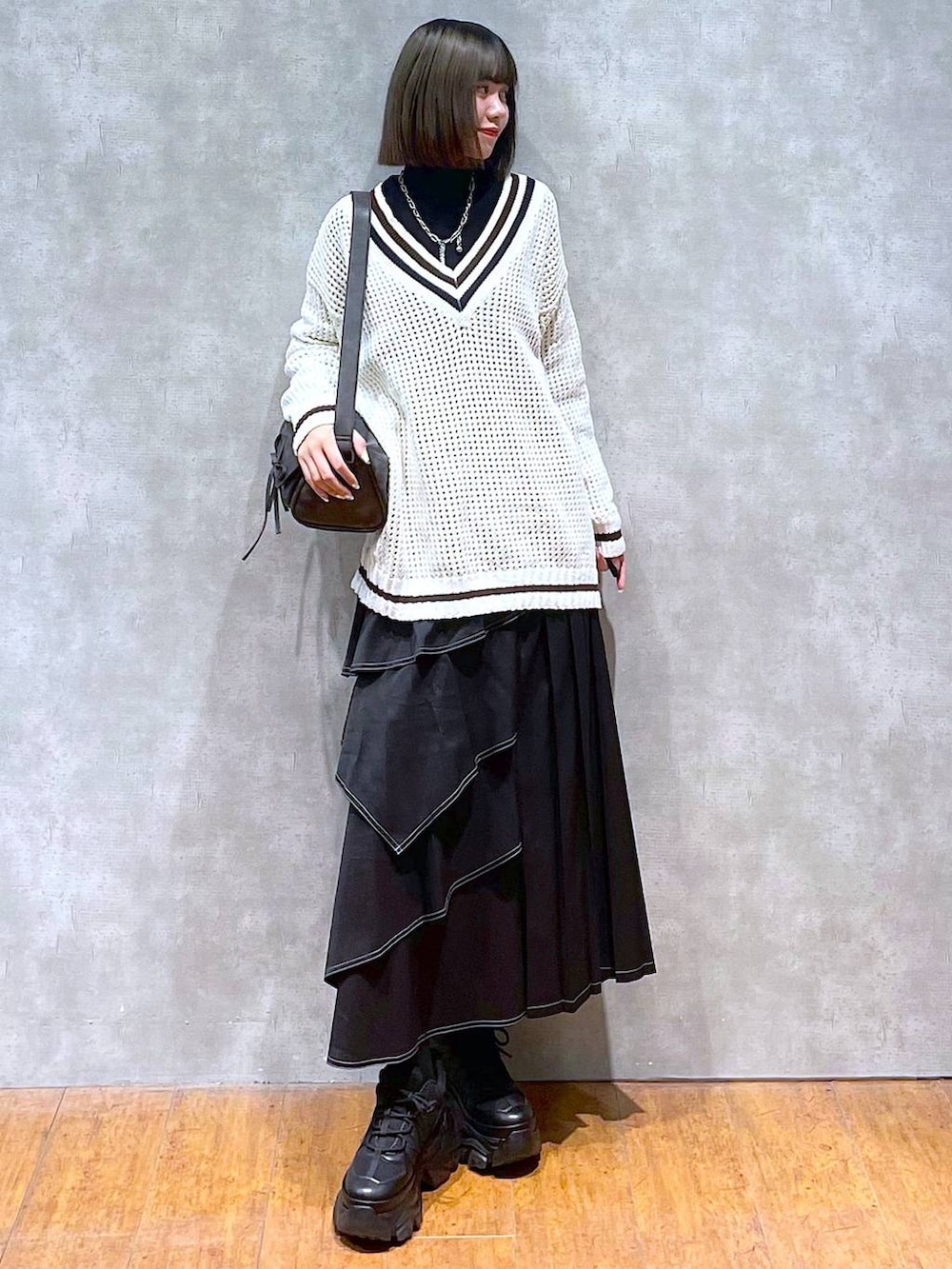 ブラック系のスニーカー、ブラック系のニット/セーター、ブラック系のショルダーバッグを着用したレディースの秋コーディネートの8枚目の写真