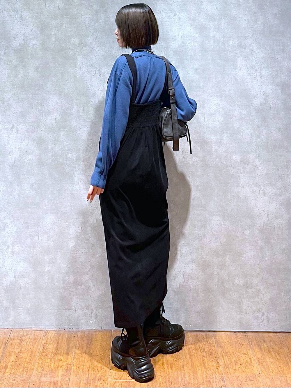 ブラック系のショルダーバッグ、ブラック系のブーツ、ブルー系のニット/セーターを着用したレディースの秋コーディネートの6枚目の写真