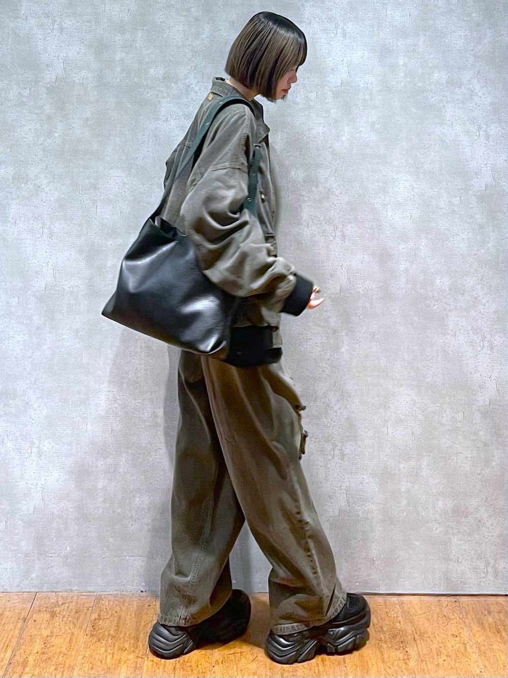 ブラック系のスニーカー、ブラック系のデニムパンツ、ブラック系のブルゾンを着用したレディースの秋コーディネートの8枚目の写真