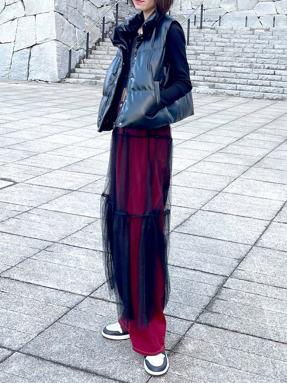 ブラック系のワンピース、レッド系のその他パンツを着用したレディースの秋コーディネートの2枚目の写真