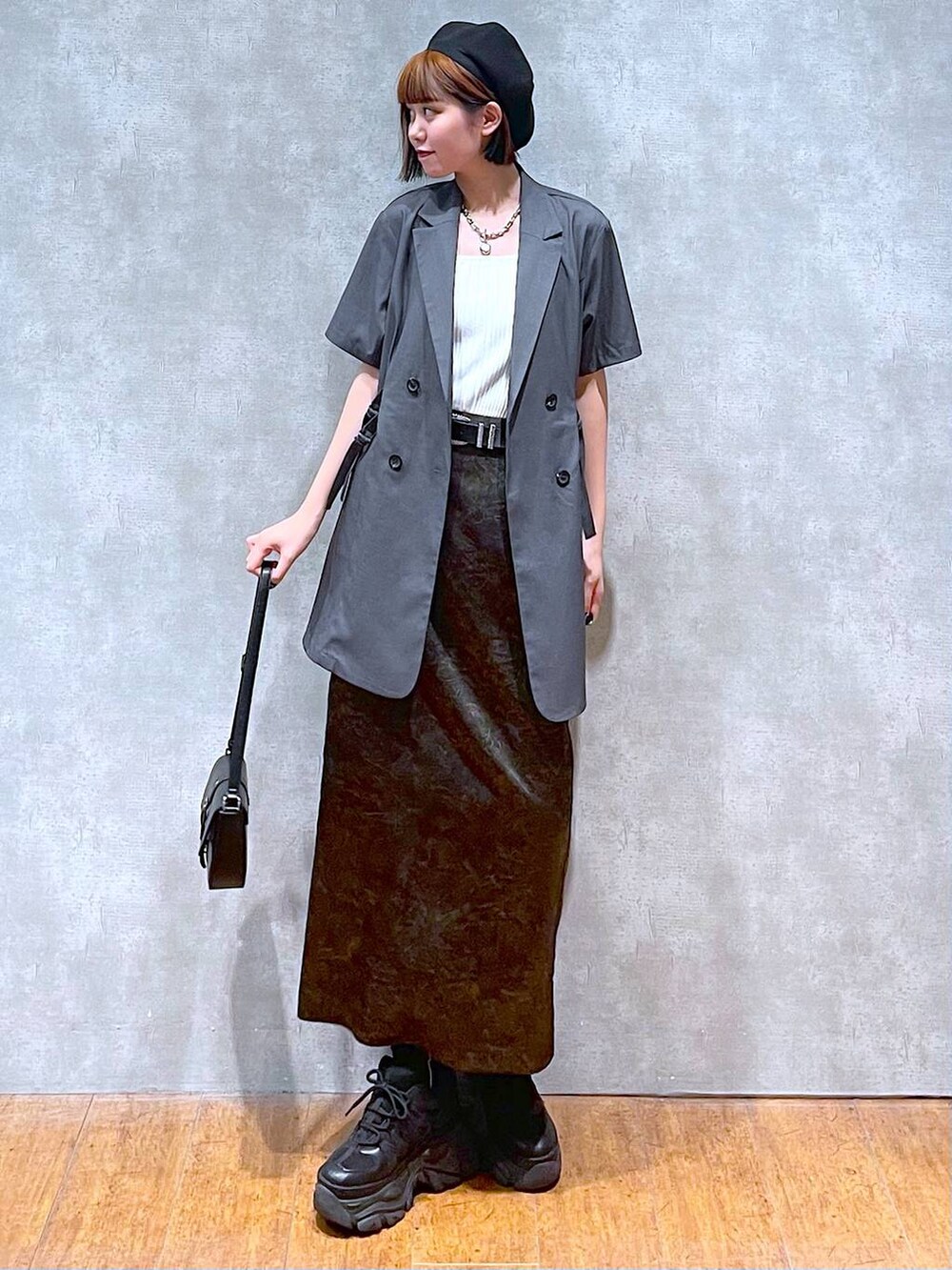 ホワイト系のタンクトップ、ブラック系のスニーカー、ブラック系のハンドバッグを着用したレディースの夏コーディネートの3枚目の写真