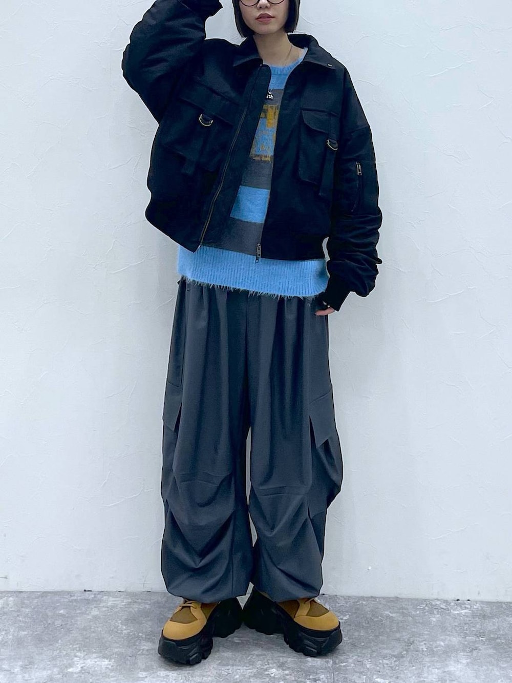 ブラウン系のブーツ、ブラック系のブルゾン、グレー系のカーゴパンツを着用したレディースの秋コーディネートの9枚目の写真