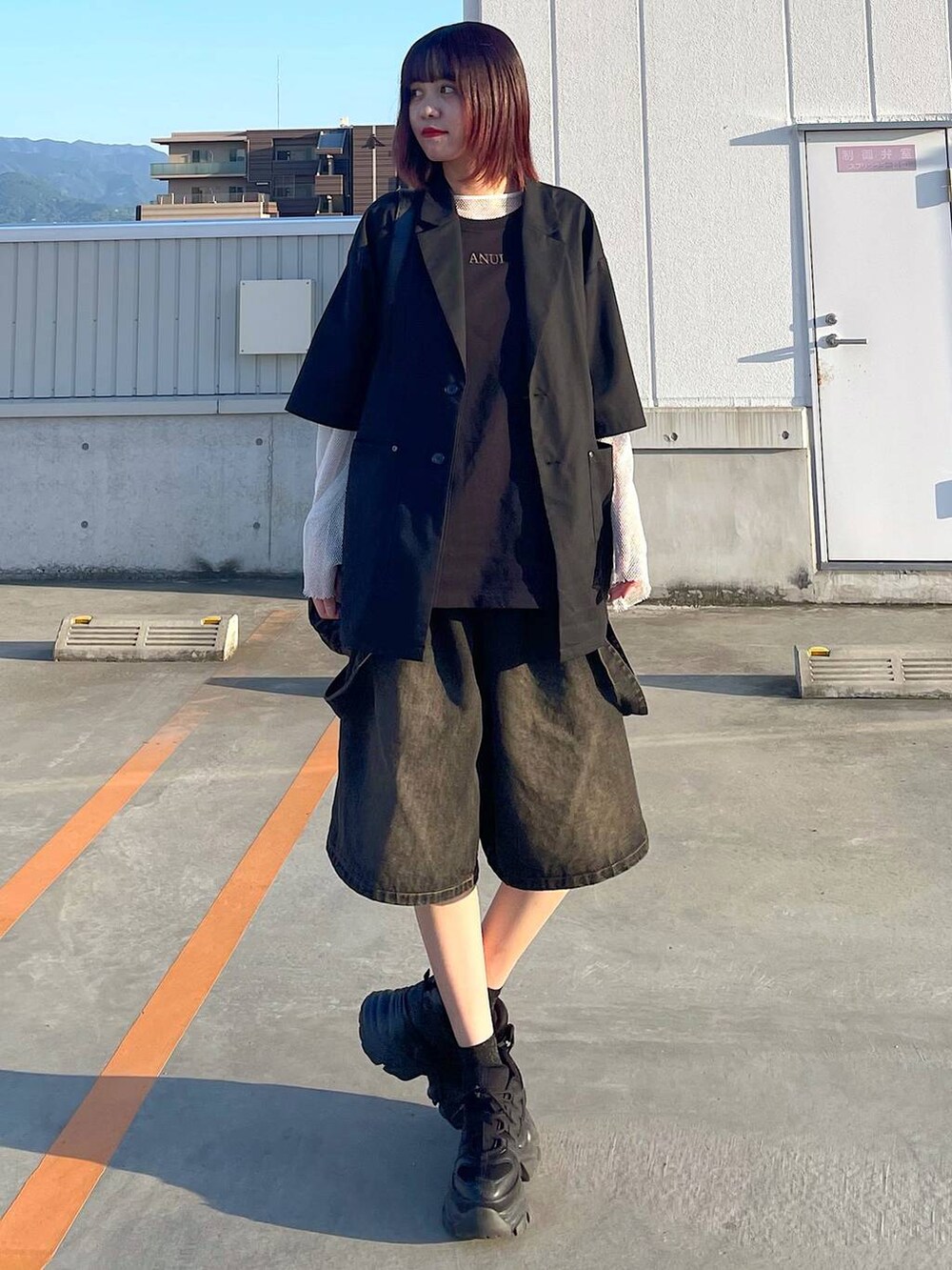 ブラック系のショルダーバッグ、ブラック系のスニーカー、ホワイト系のTシャツ/カットソーを着用したレディースの春コーディネートの4枚目の写真