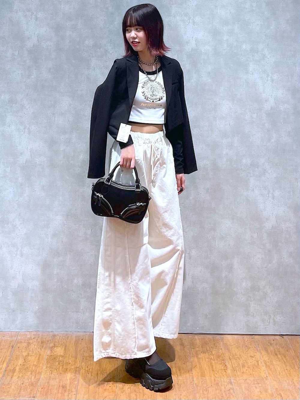 ホワイト系のTシャツ/カットソー、ブラック系のテーラードジャケット、ブラック系のボストンバッグを着用したレディースの春コーディネートの2枚目の写真