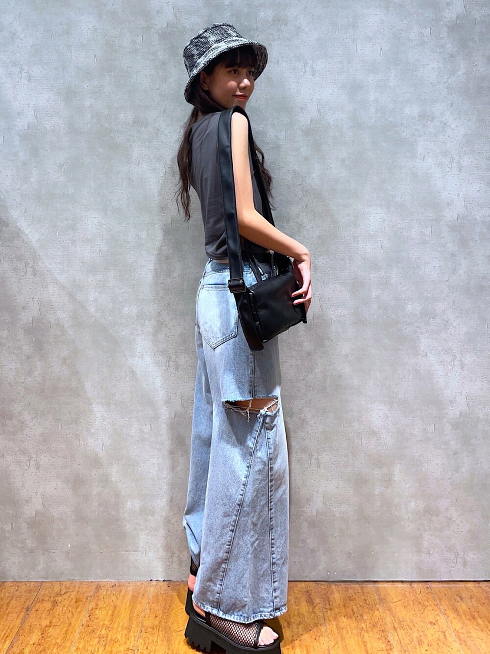 グレー系のTシャツ/カットソー、ブラック系のショルダーバッグ、ブルー系のデニムパンツを着用したレディースの夏コーディネートの2枚目の写真