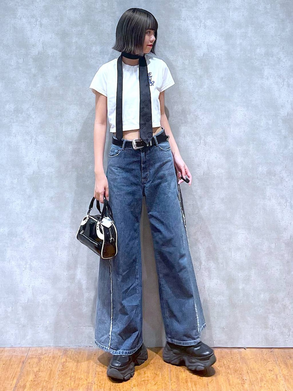 ブラック系のスニーカー、ホワイト系のTシャツ/カットソー、ブラック系のネクタイを着用したレディースの夏コーディネートの9枚目の写真