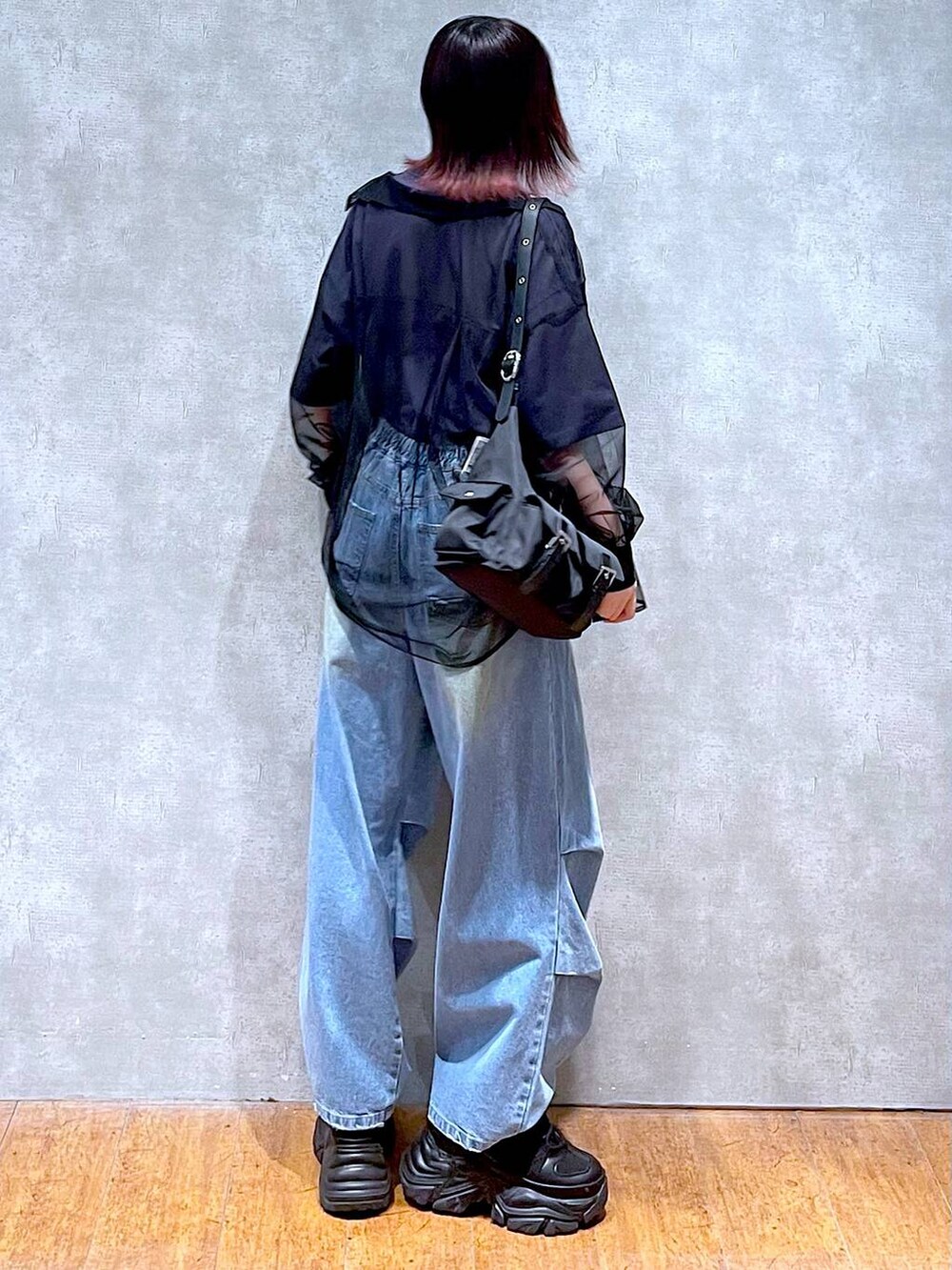 ブラック系のショルダーバッグ、ブルー系のデニムパンツ、ブラック系のスニーカーを着用したレディースの春コーディネートの7枚目の写真