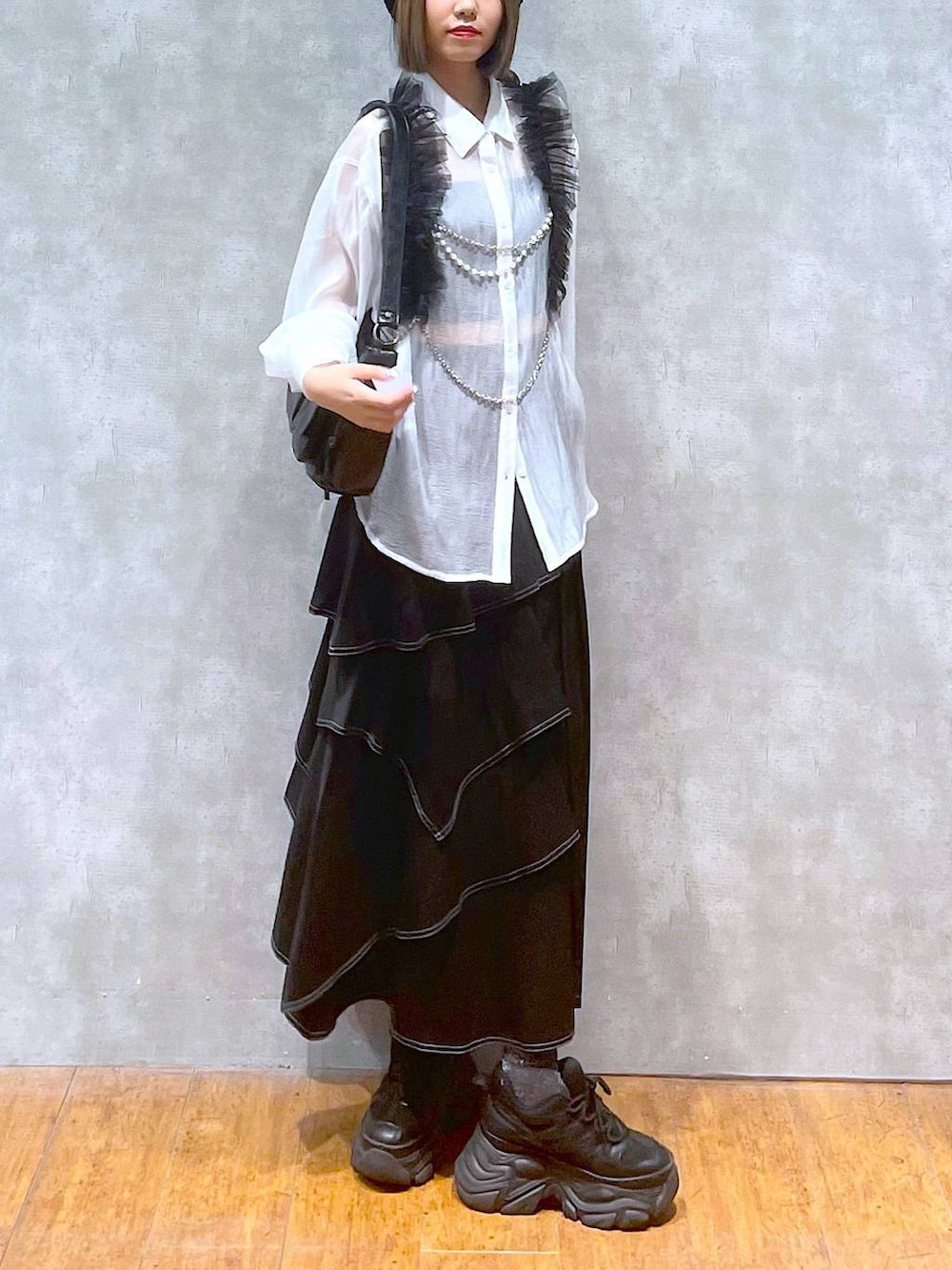 ブラック系のスニーカー、ホワイト系のシャツ/ブラウス、ブラック系のショルダーバッグを着用したレディースの秋コーディネートの6枚目の写真