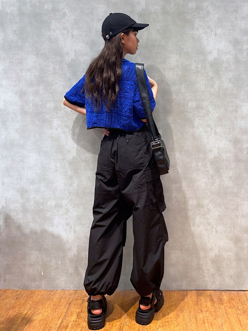 ブルー系のカーディガン/ボレロ、ブラック系のキャミソール、ブラック系のショルダーバッグを着用したレディースの夏コーディネートの2枚目の写真