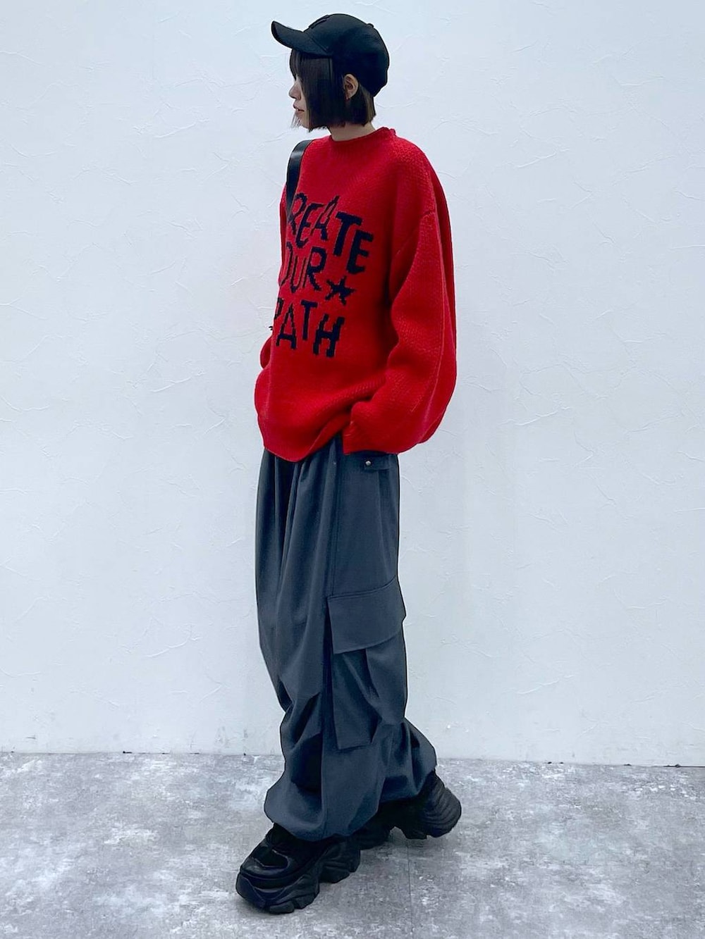 ブラック系のショルダーバッグ、ブラック系のスニーカー、グレー系のカーゴパンツを着用したレディースの秋コーディネートの3枚目の写真