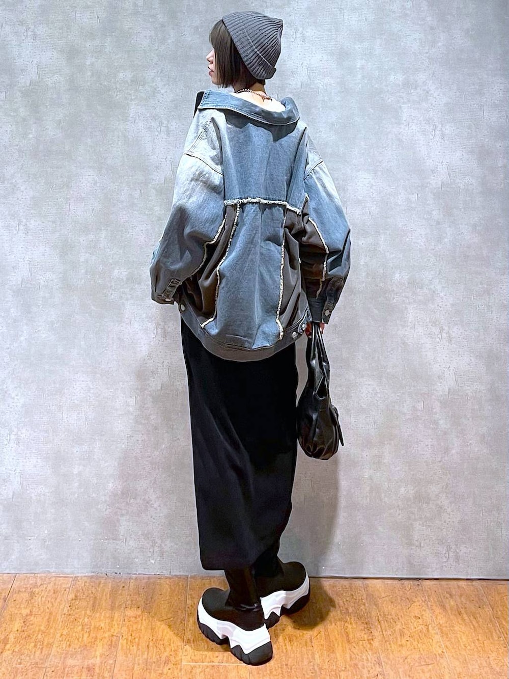 ブルー系のブルゾン、ブラック系のハンドバッグ、ホワイト系のTシャツ/カットソーを着用したレディースの秋コーディネートの4枚目の写真