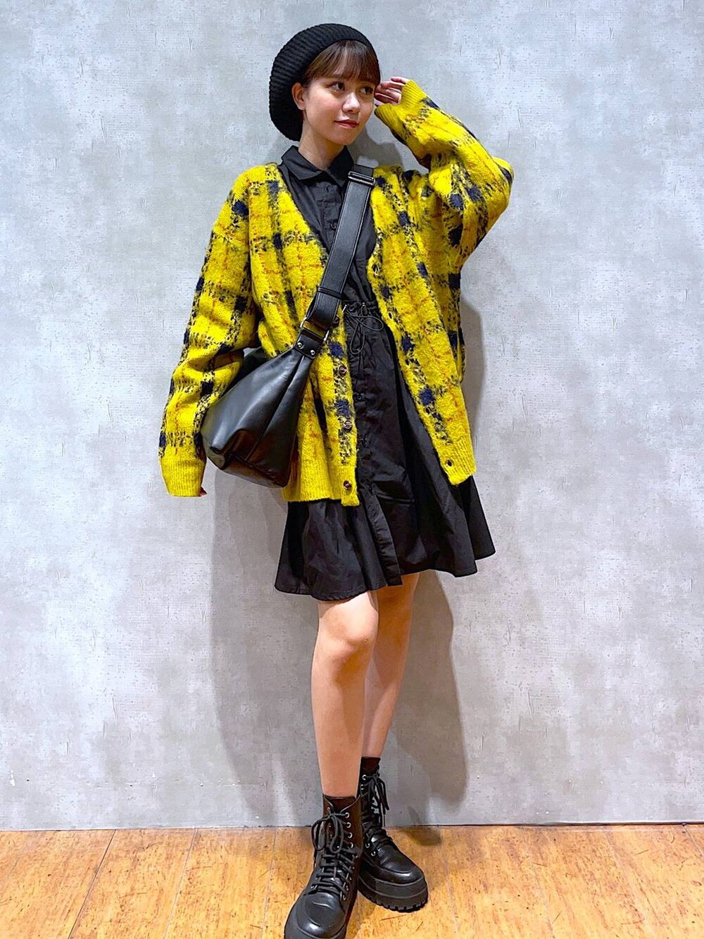 ブラック系のブーツ、イエロー系のカーディガン/ボレロ、ブラック系のショルダーバッグを着用したレディースの秋コーディネートの3枚目の写真
