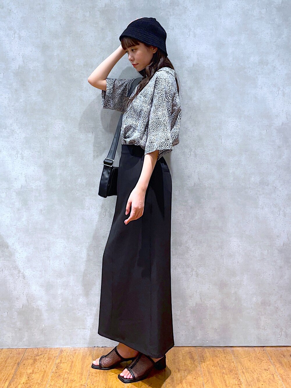 ホワイト系のシャツ/ブラウス、ホワイト系のショルダーバッグ、ブラック系のスカートを着用したレディースの夏コーディネートの2枚目の写真
