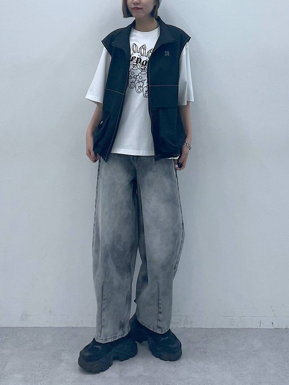 ブラック系のスニーカー、ブラック系のデニムパンツ、ホワイト系のTシャツ/カットソーを着用したレディースの夏コーディネートの5枚目の写真