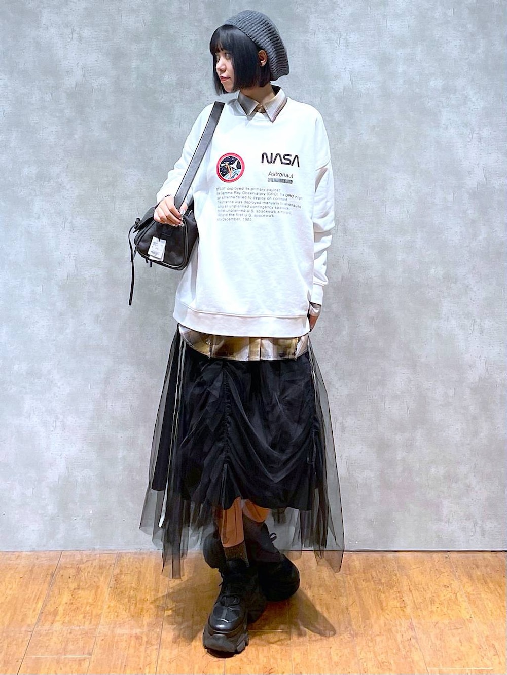 ブラック系のスニーカー、ブラック系のショルダーバッグ、ブラック系のスカートを着用したレディースの秋コーディネートの7枚目の写真