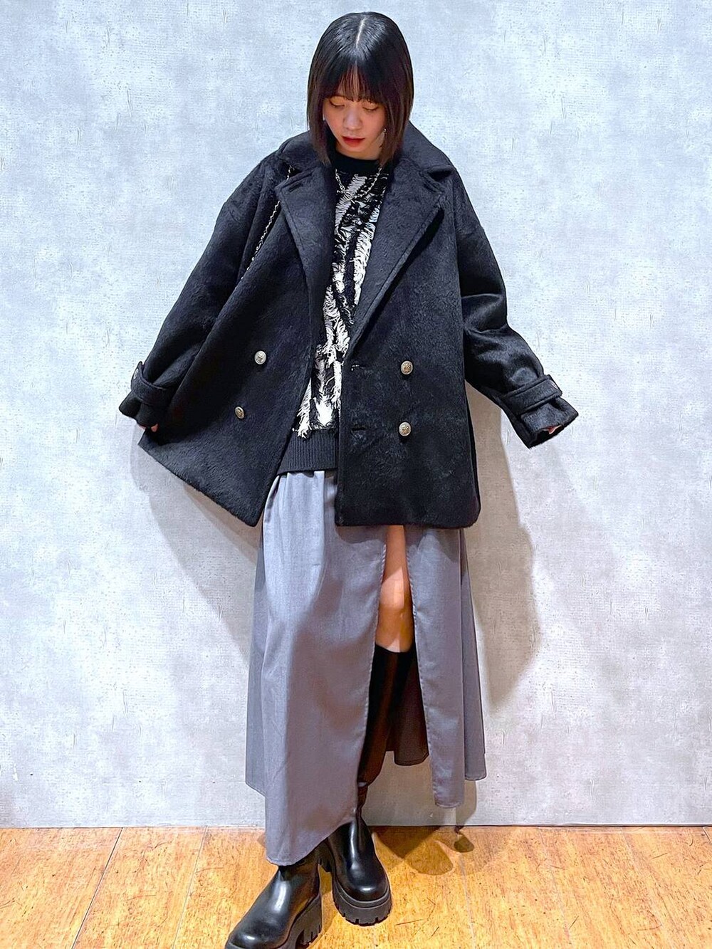 ブラック系のブーツ、グレー系のスカート、ブラック系のニット/セーターを着用したレディースの冬コーディネートの3枚目の写真