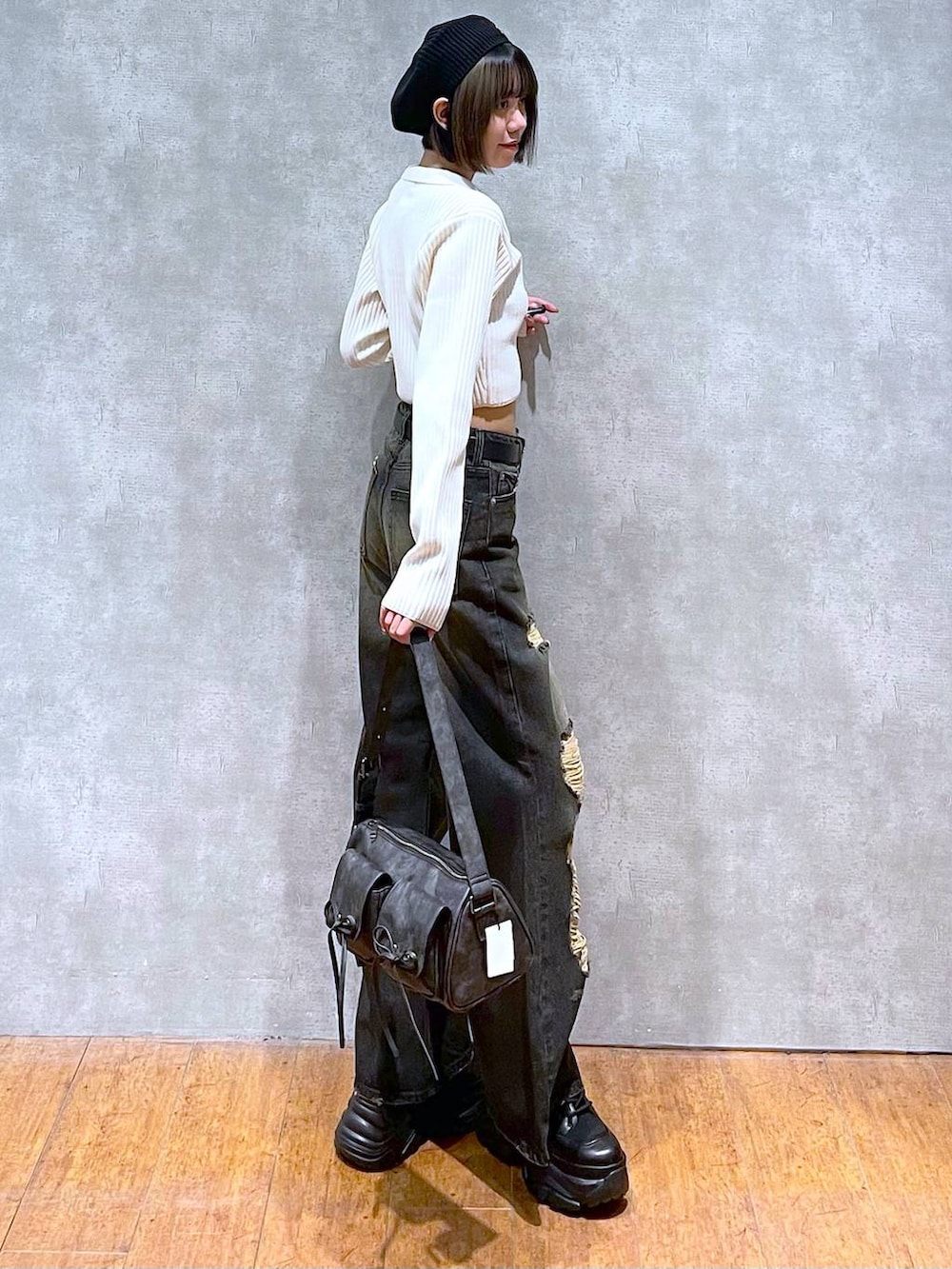 ブラック系のショルダーバッグ、ブラック系のブーツ、ブラック系のキャミソールを着用したレディースの秋コーディネートの5枚目の写真