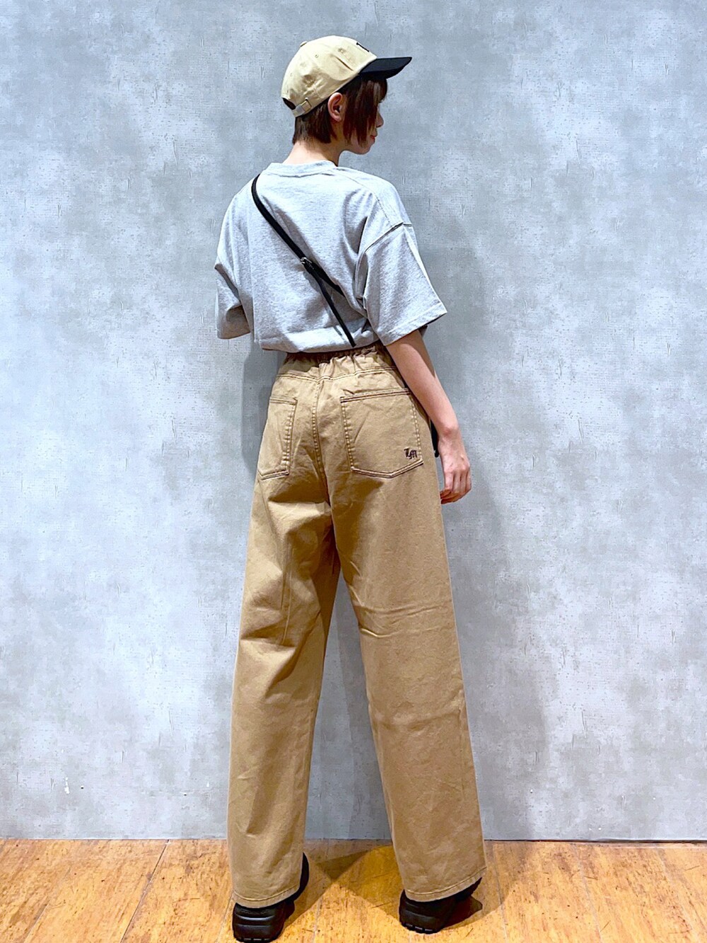 グレー系のTシャツ/カットソー、ブラック系のショルダーバッグ、ベージュ系のその他パンツを着用したレディースの夏コーディネートの2枚目の写真