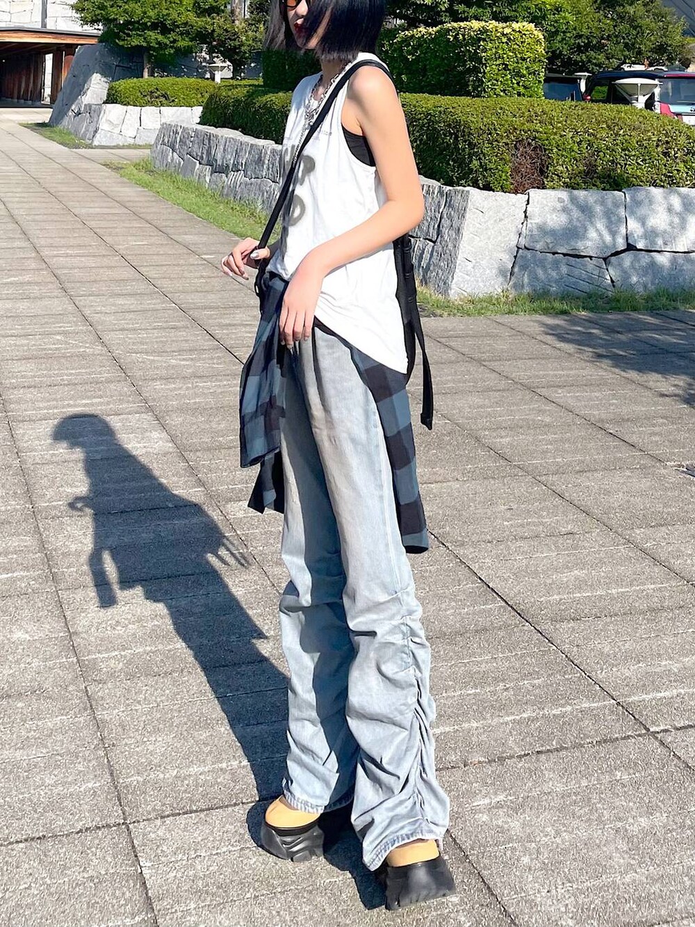 ホワイト系のTシャツ/カットソー、ブルー系のデニムパンツ、ブラウン系のブーツを着用したレディースの秋コーディネートの4枚目の写真