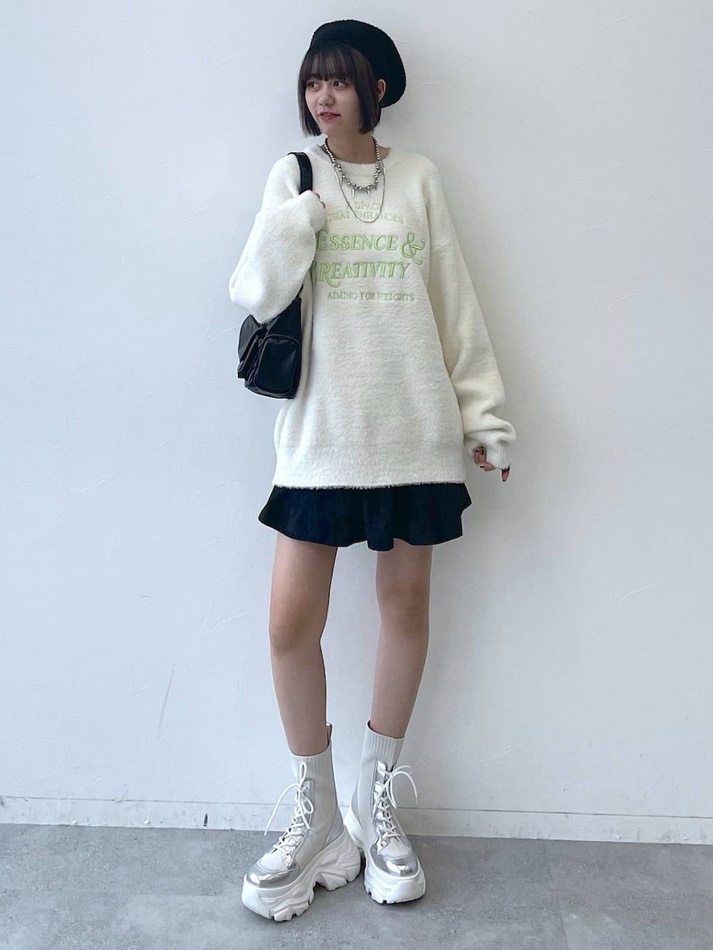 ホワイト系のブーツ、ブラック系のショルダーバッグ、ホワイト系のニット/セーターを着用したレディースの秋コーディネートの7枚目の写真