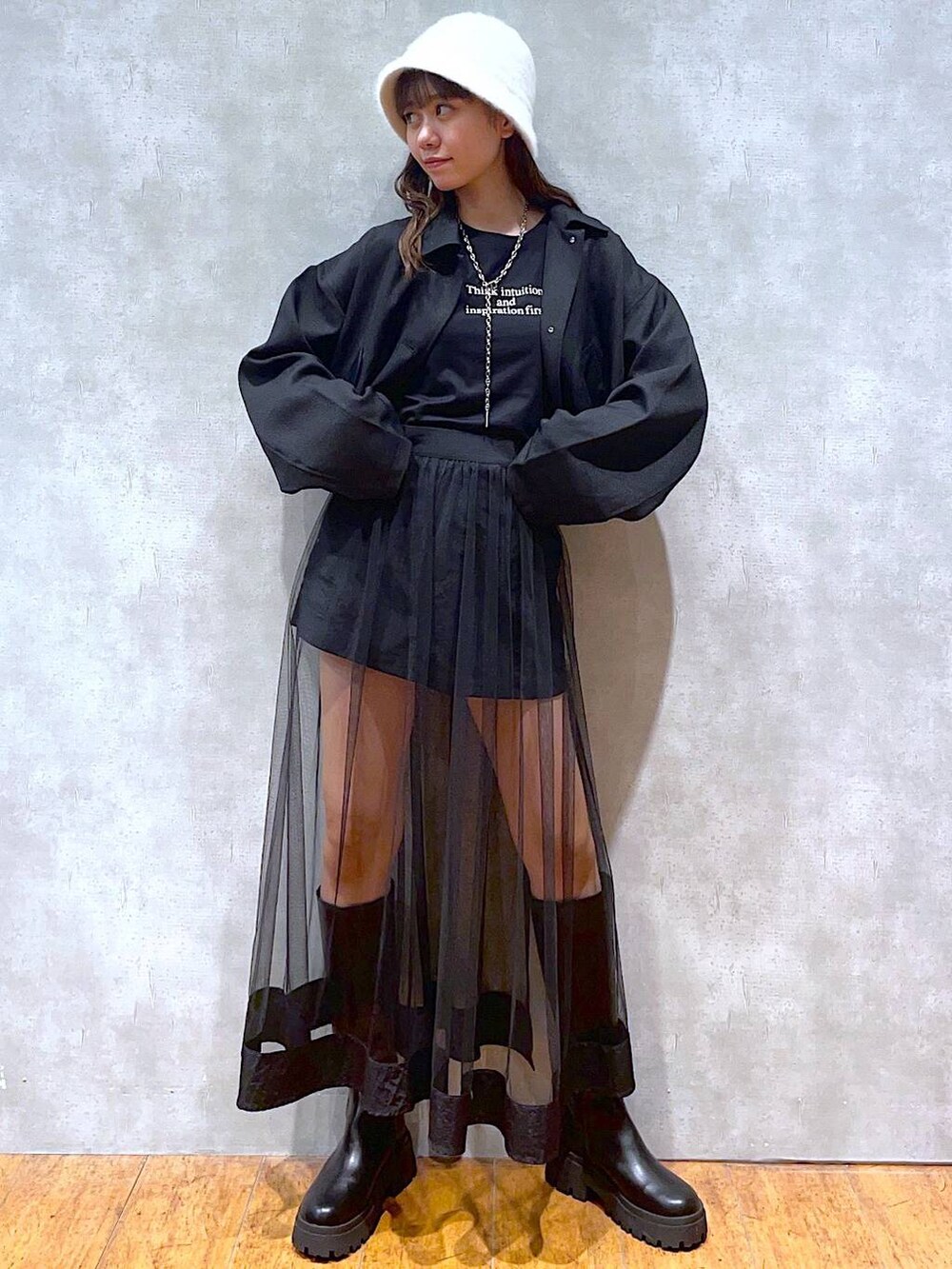 ブラック系のベスト、ブラック系のブーツ、ブラック系のスカートを着用したレディースの秋コーディネートの2枚目の写真