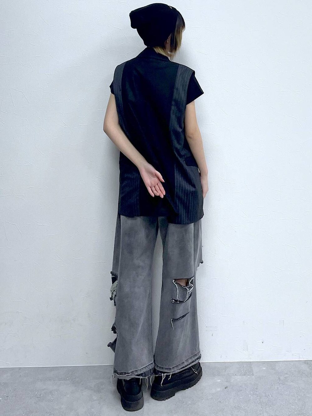 ブラック系のデニムパンツ、ブラック系のTシャツ/カットソー、ブラック系のブーツを着用したレディースの冬コーディネートの6枚目の写真