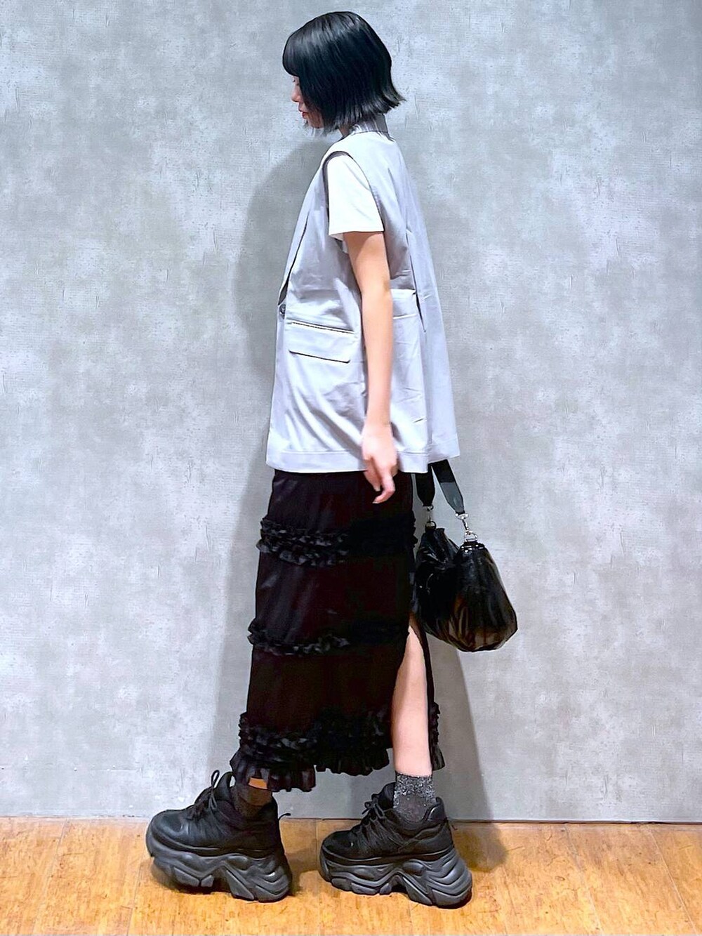 ブラック系のスニーカー、ホワイト系のTシャツ/カットソー、ブラック系のショルダーバッグを着用したレディースの夏コーディネートの3枚目の写真