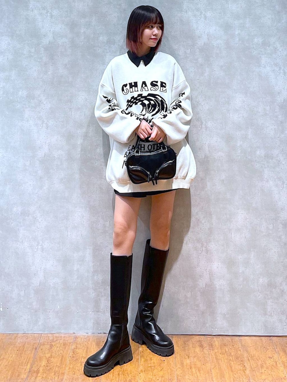 ブラック系のシャツ/ブラウス、ホワイト系のニット/セーター、ブラック系のブーツを着用したレディースの冬コーディネートの2枚目の写真