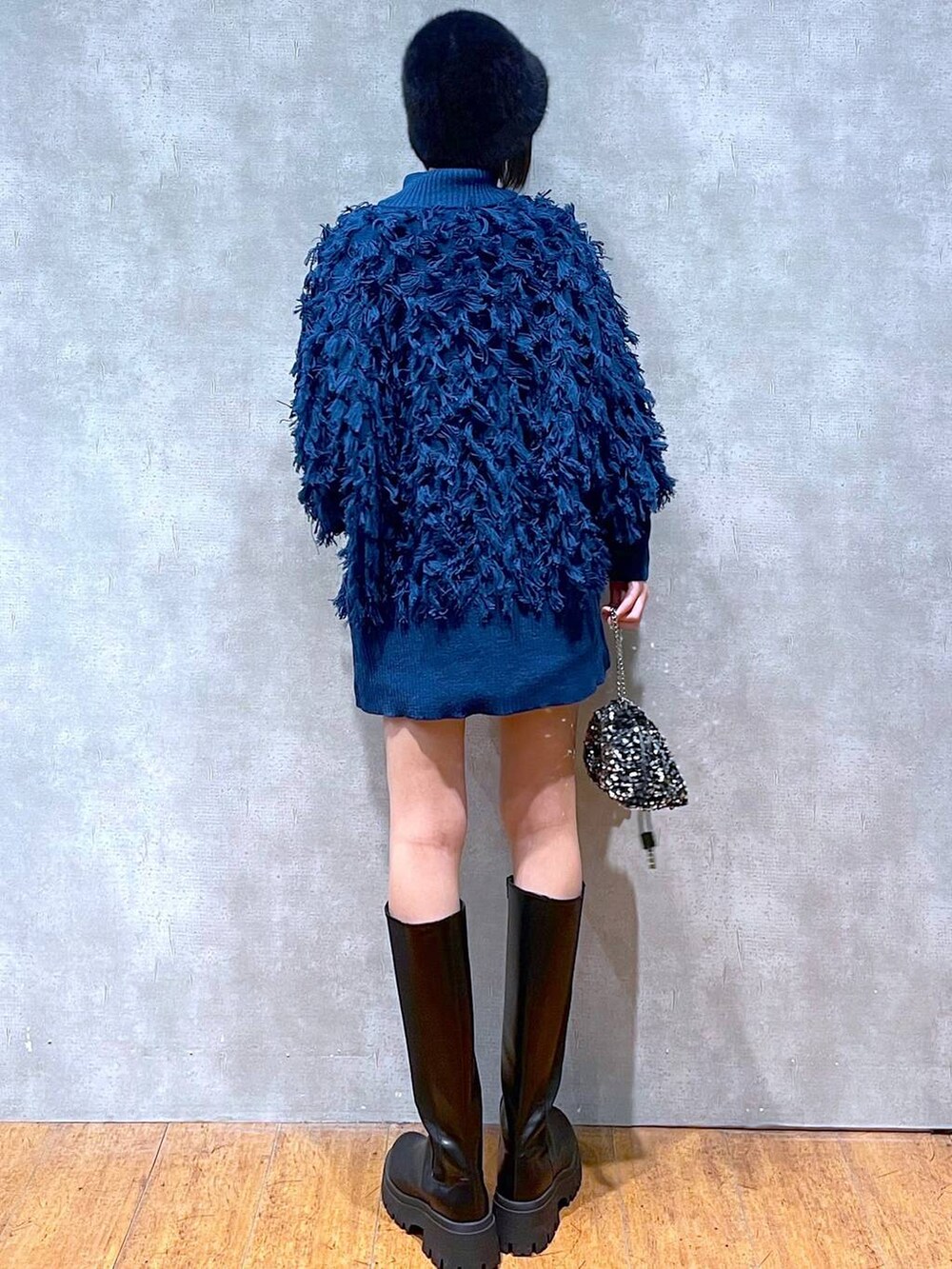 ブラック系のブーツ、ブラック系のニット/セーター、シルバー系のショルダーバッグを着用したレディースの冬コーディネートの5枚目の写真