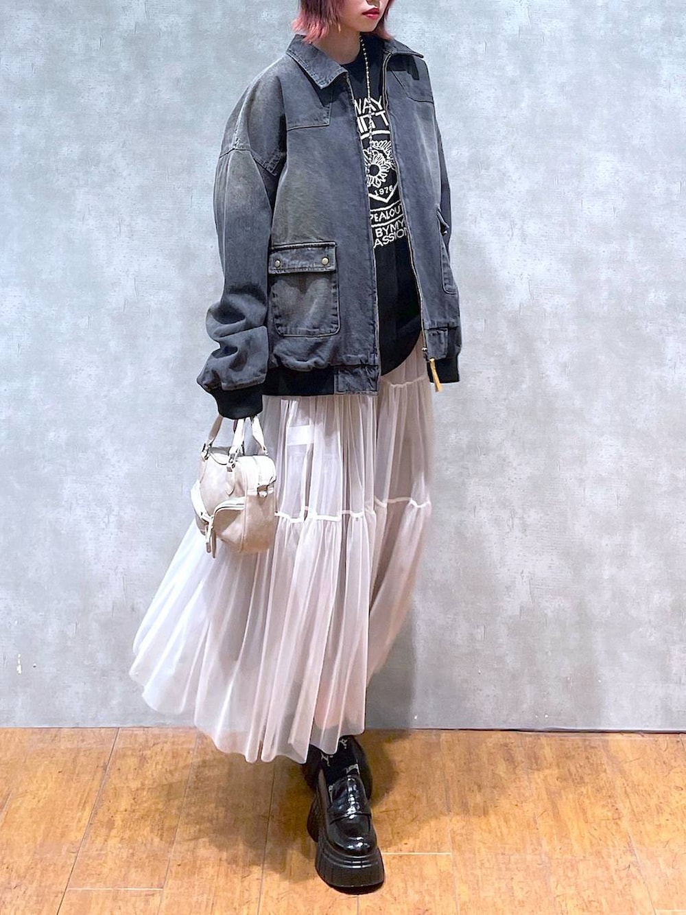 ブラック系のニット/セーター、ブラック系のデニムジャケット、ホワイト系のスカートを着用したレディースの冬コーディネートの9枚目の写真