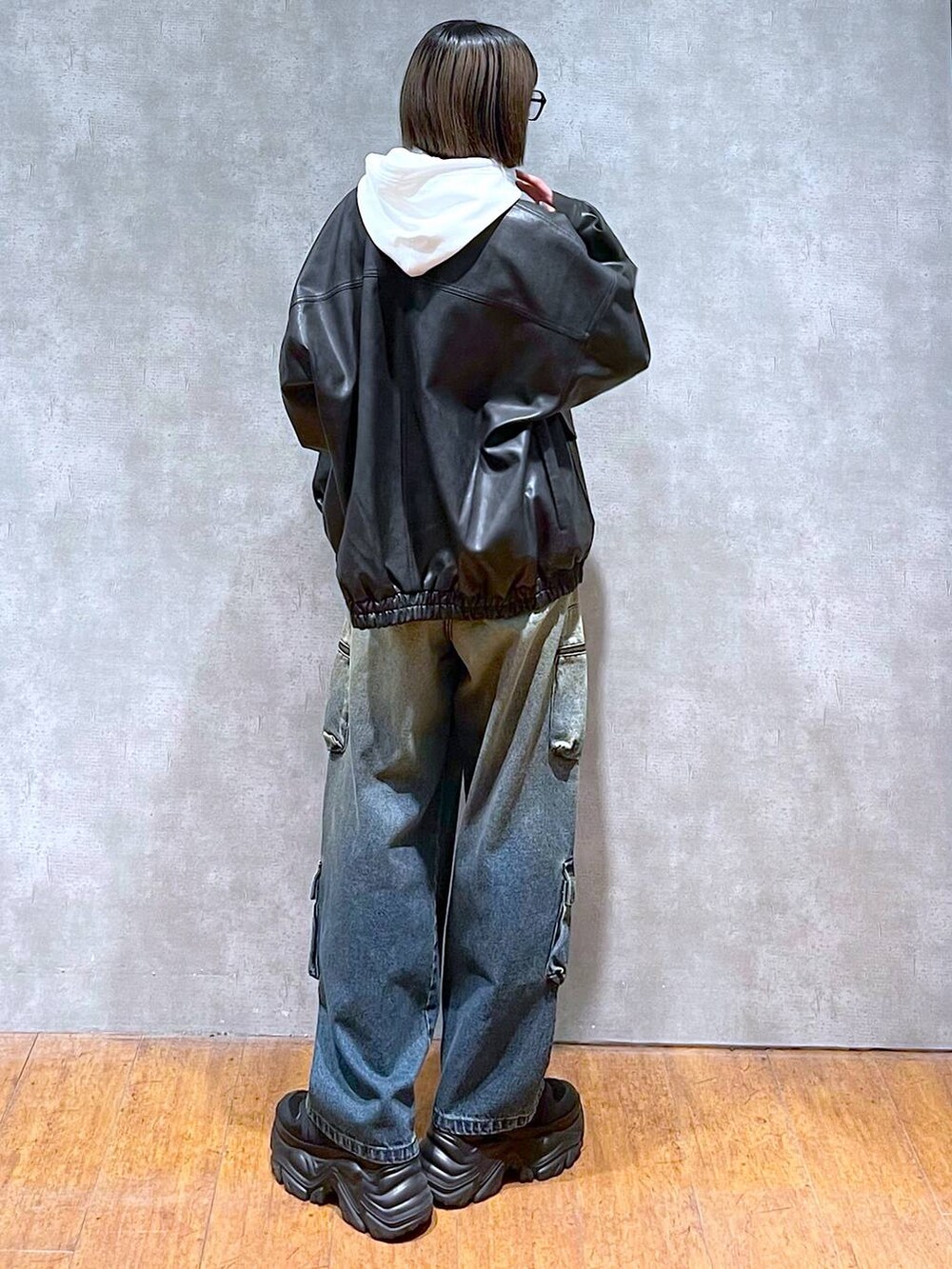 ブラック系のスニーカー、ブラック系のブルゾン、ブルー系のデニムパンツを着用したレディースの秋コーディネートの4枚目の写真