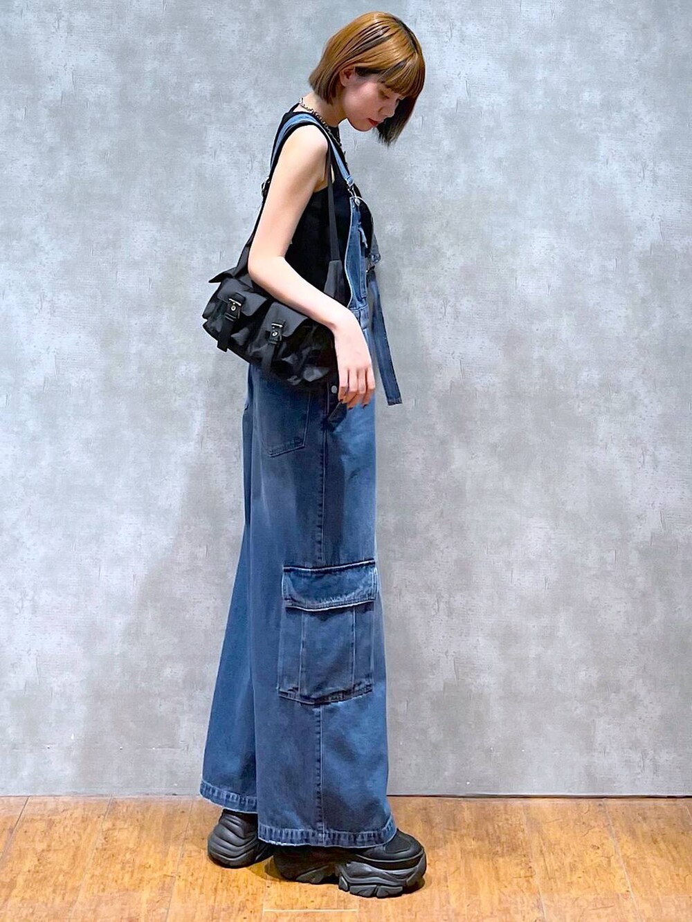 ブラック系のショルダーバッグ、ブラック系のスニーカー、ブラック系のタンクトップを着用したレディースの夏コーディネートの3枚目の写真