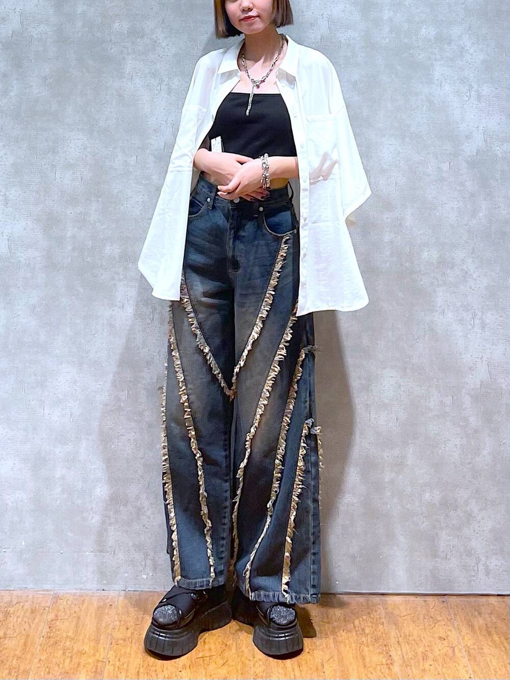 ブラック系のスニーカー、ブラック系のキャミソール、ホワイト系のシャツ/ブラウスを着用したレディースの夏コーディネートの2枚目の写真