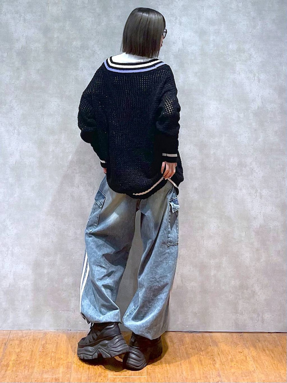 ブラック系のスニーカー、ブルー系のデニムパンツ、ブラック系のニット/セーターを着用したレディースの秋コーディネートの8枚目の写真