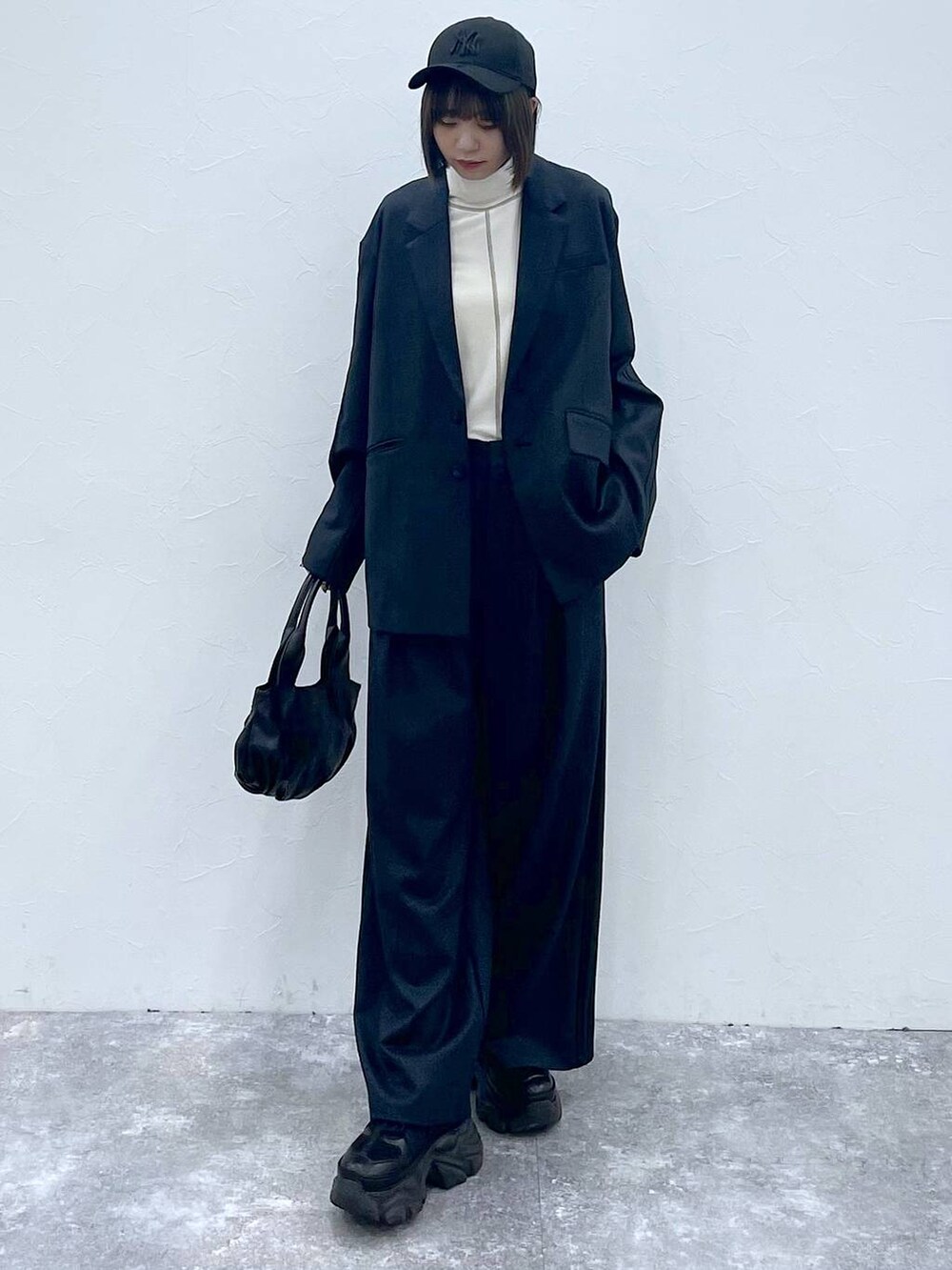 ブラック系のスニーカー、ブラック系のスラックス、ブラック系のテーラードジャケットを着用したレディースの秋コーディネートの7枚目の写真