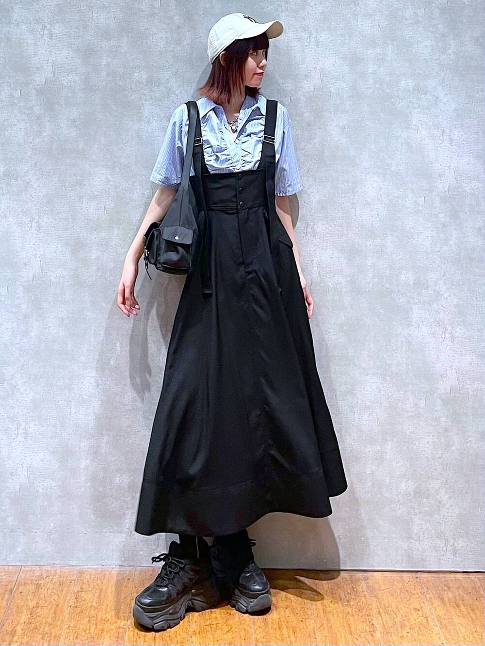 ブラック系のショルダーバッグ、ブラック系のスニーカー、ブラック系のスカートを着用したレディースの春コーディネートの2枚目の写真