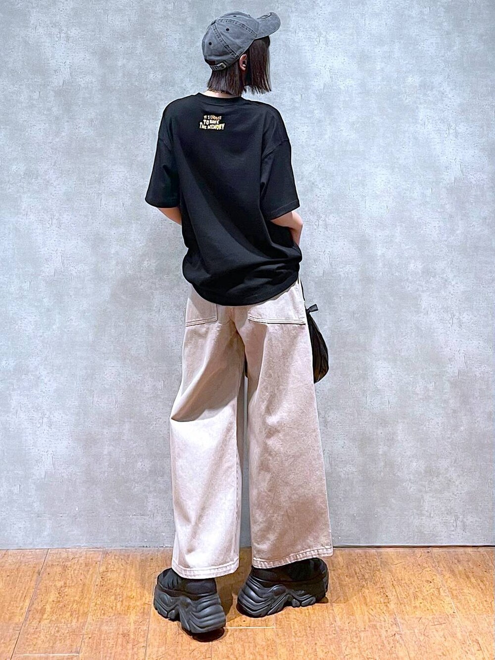 ブラック系のスニーカー、ブラック系のショルダーバッグ、ベージュ系のデニムパンツを着用したレディースの夏コーディネートの6枚目の写真