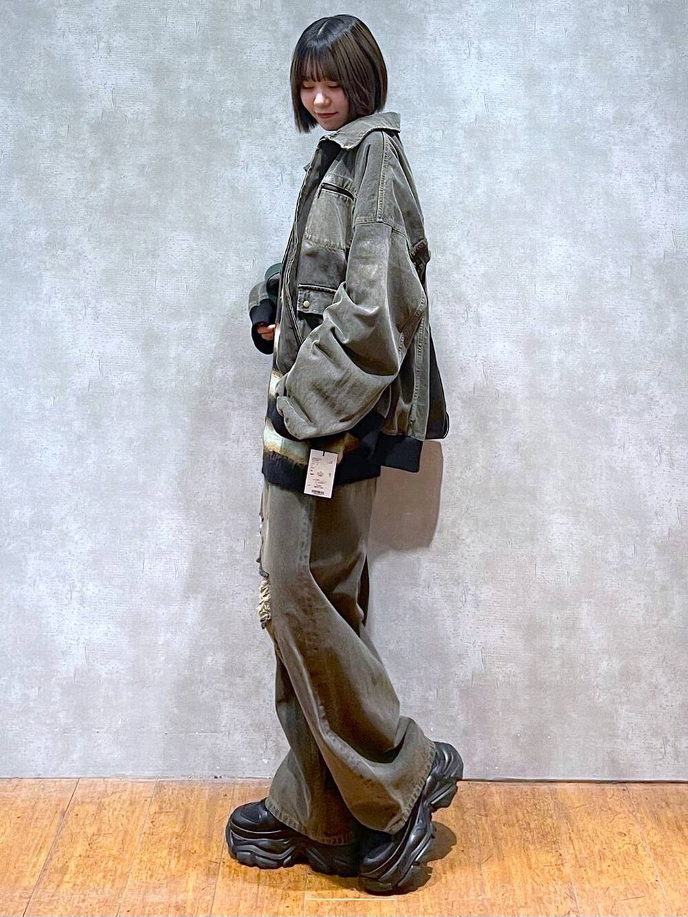 ブラック系のスニーカー、ブラック系のデニムパンツ、ブラック系のブルゾンを着用したレディースの秋コーディネートの6枚目の写真