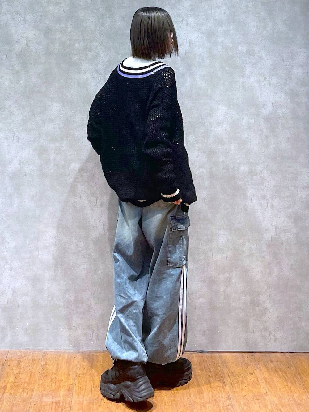 ブラック系のスニーカー、ブルー系のデニムパンツ、ブラック系のニット/セーターを着用したレディースの秋コーディネートの7枚目の写真