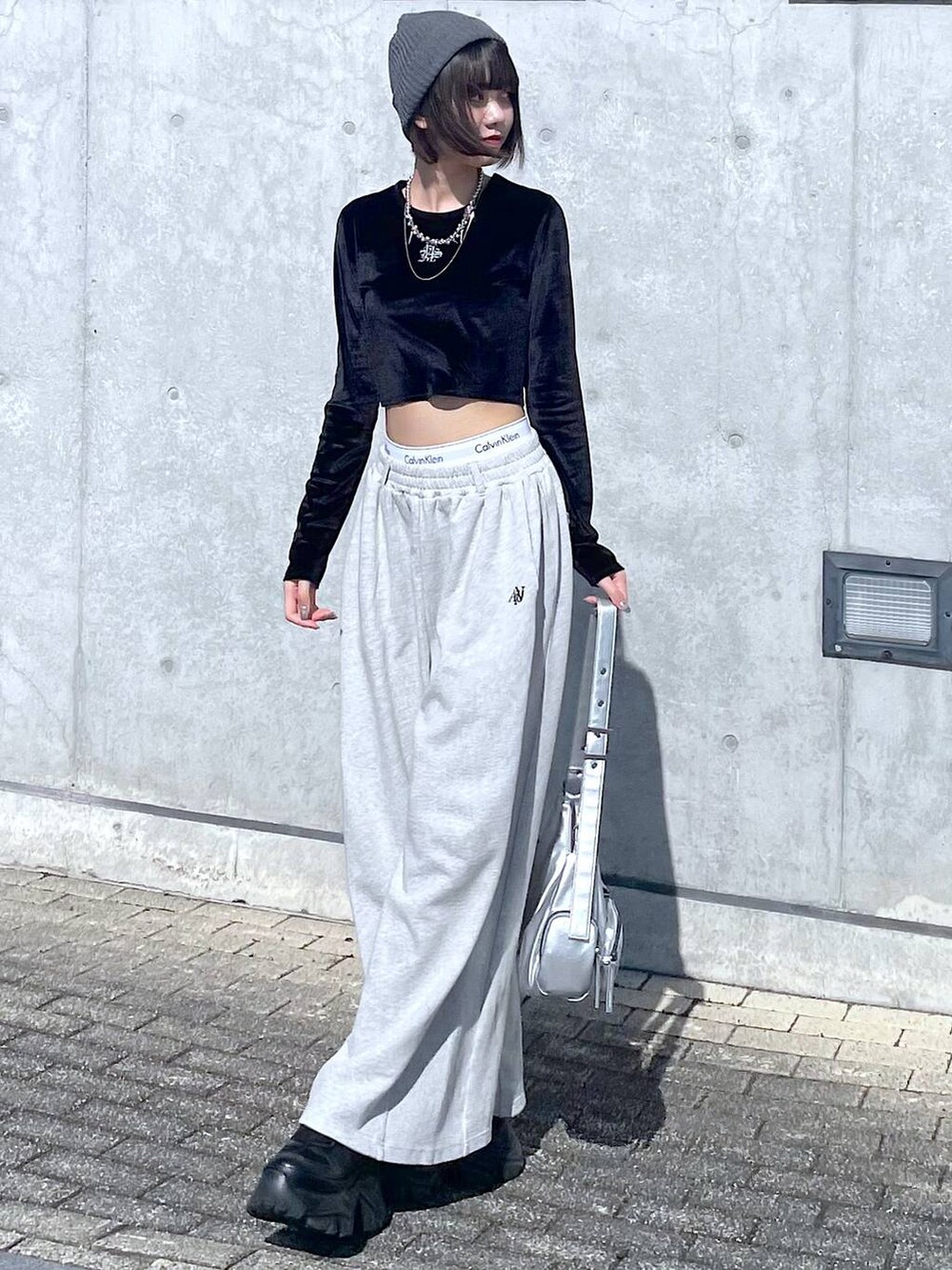 ブラック系のスニーカー、シルバー系のショルダーバッグ、ブラック系のTシャツ/カットソーを着用したレディースの秋コーディネートの3枚目の写真