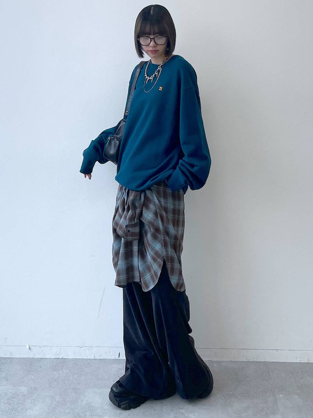 ブラック系のスニーカー、ブラック系のショルダーバッグ、グリーン系のスウェットを着用したレディースの秋コーディネートの8枚目の写真