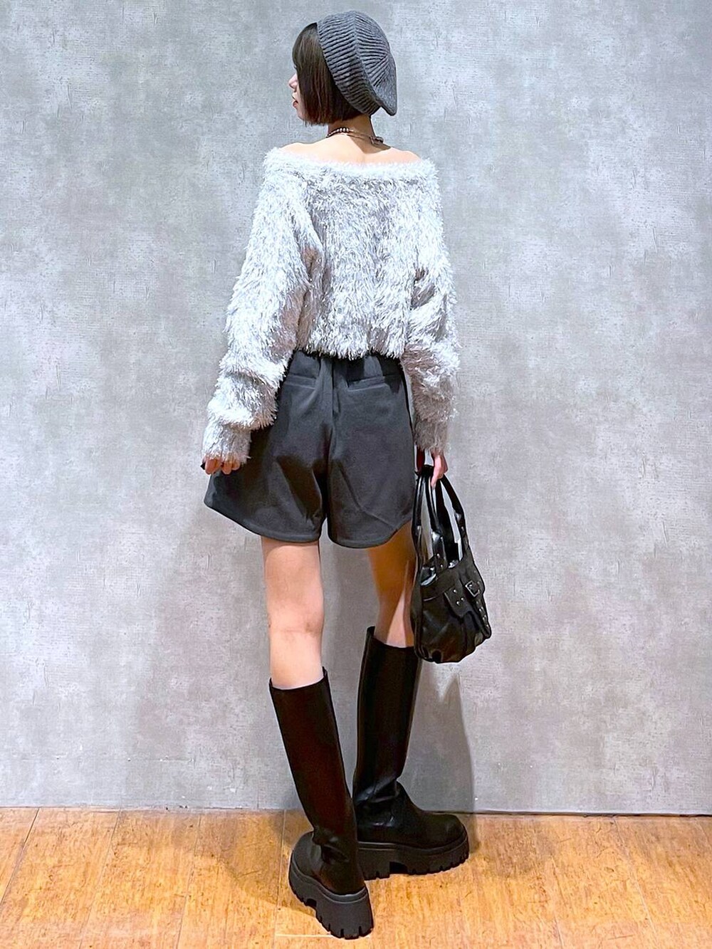 グレー系のその他パンツ、ブラック系のハンドバッグ、ブラック系のブーツを着用したレディースの秋コーディネートの3枚目の写真