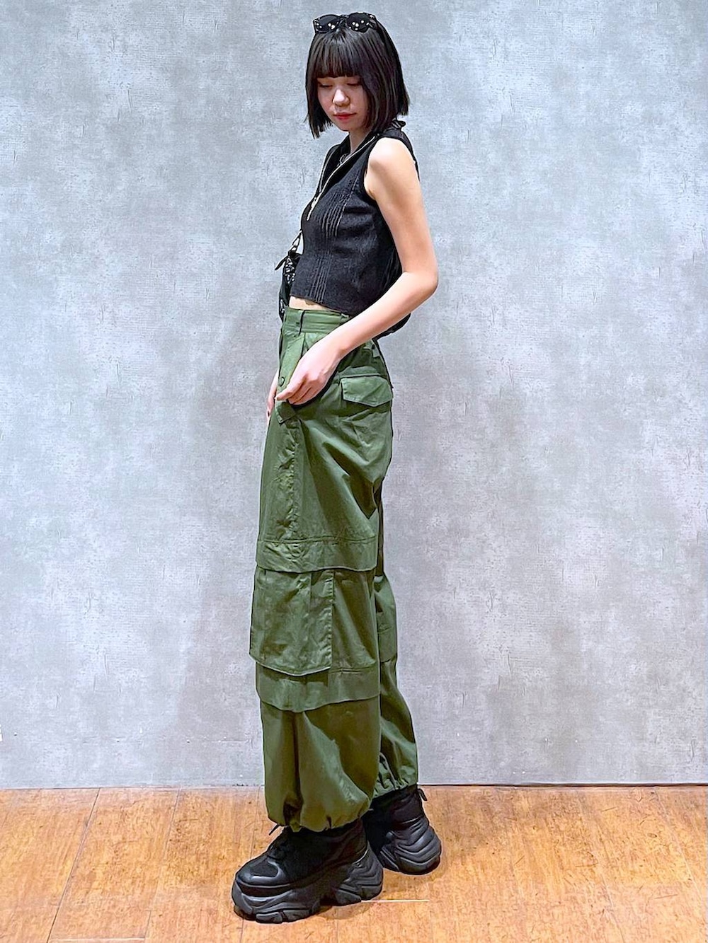 ブラック系のスニーカー、ブラック系のニット/セーター、グリーン系のその他パンツを着用したレディースの夏コーディネートの4枚目の写真