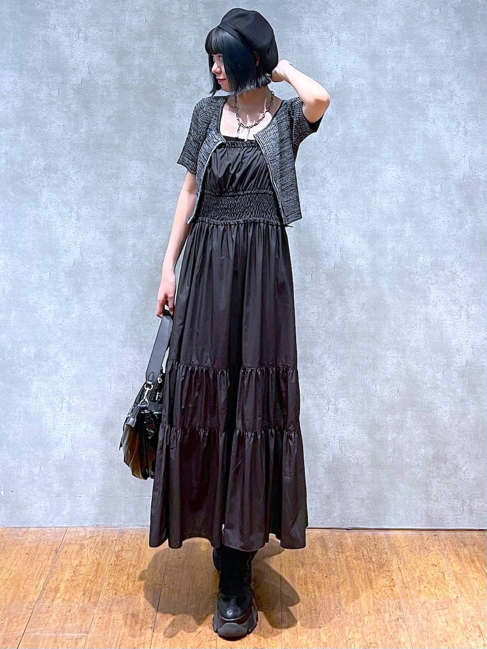 ブラック系のスニーカー、ブラック系のショルダーバッグ、ブラック系のワンピースを着用したレディースの夏コーディネートの2枚目の写真