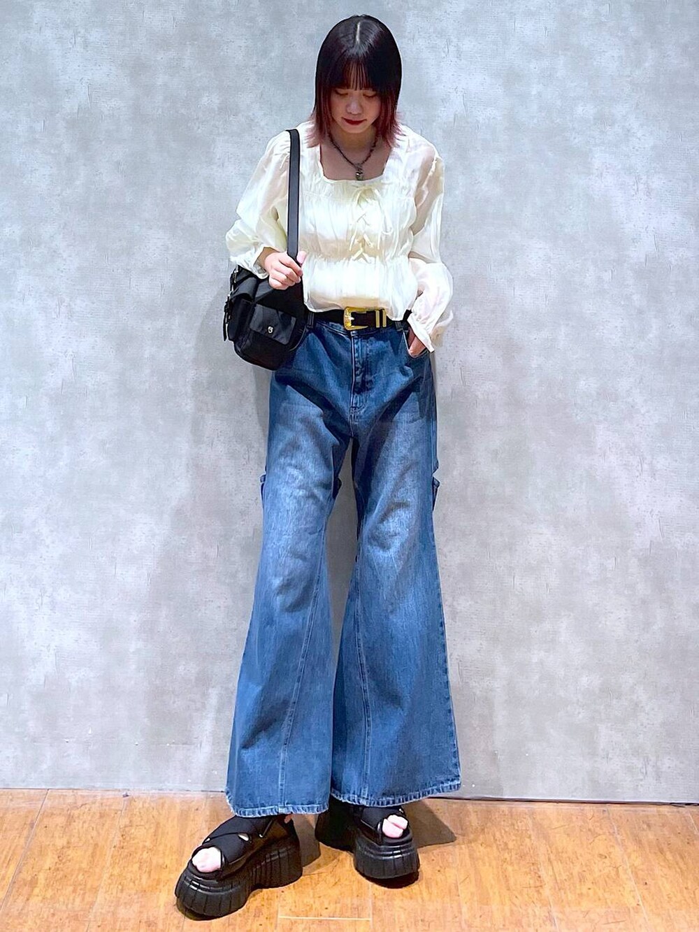 ブラック系のスニーカー、ブラック系のショルダーバッグ、ベージュ系のシャツ/ブラウスを着用したレディースの春コーディネートの2枚目の写真