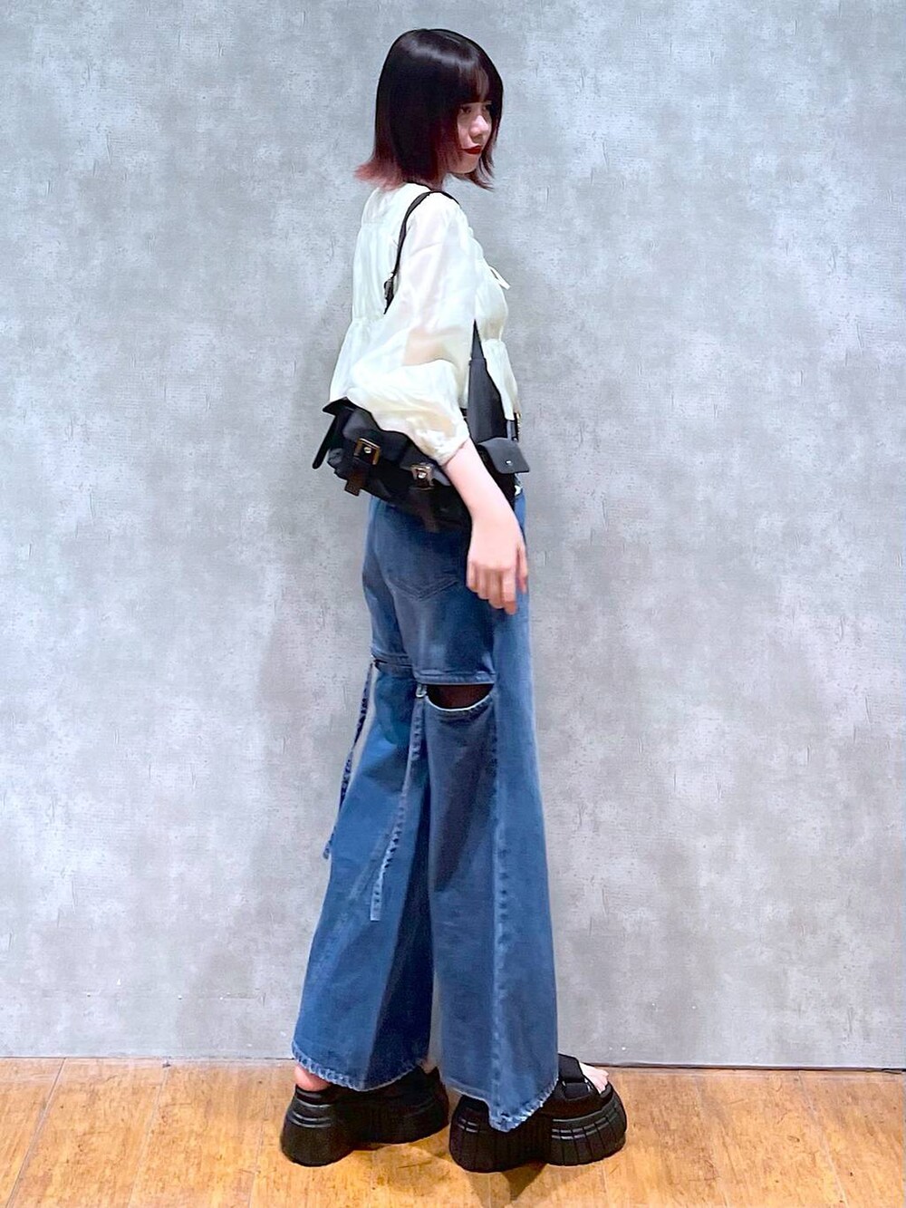 ブラック系のスニーカー、ブラック系のショルダーバッグ、ベージュ系のシャツ/ブラウスを着用したレディースの春コーディネートの4枚目の写真